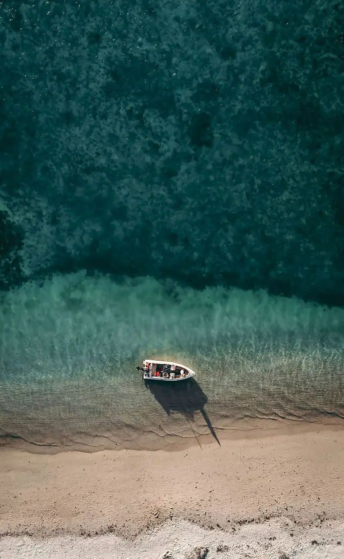 a small boat on the shore of a beach